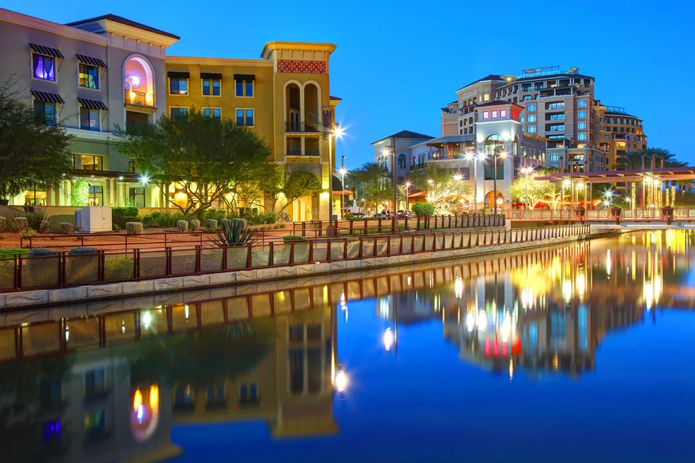 A city street with buildings lit up at night.